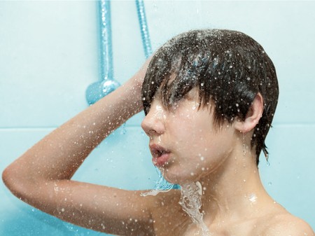 Boy bathing under a shower Reklamní fotografie