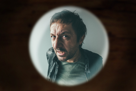 スパイホール 借金コレクターやドアをノック犯罪者を通して見たドアで怒っている男 の写真素材 画像素材 Image