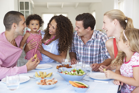 Familien, die zusammen Mahlzeit zu Hause genießen