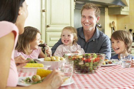 Familie, die zusammen Mahlzeit in der Küche isst