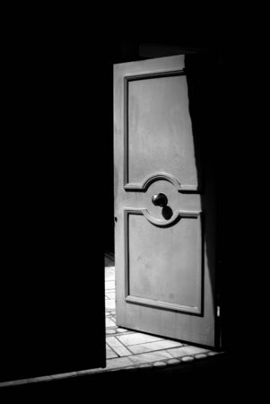 Open metallic door in black and white step into the light concept