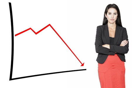 Stern professional woman displaying a concept of decline on a chart Stockfoto