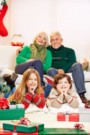 stock photo two children celebrating christmas at their grandparents with gifts - Grandparents Gifts For Christmas stock photo two children celebrating christmas at their grandparents with gifts - Grandparents Gifts For Christmas