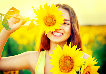 Beauty joyful teenage girl with sunflower enjoying nature - 64665216