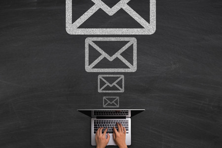 Email concept with hands typing laptop on the blackboard background
