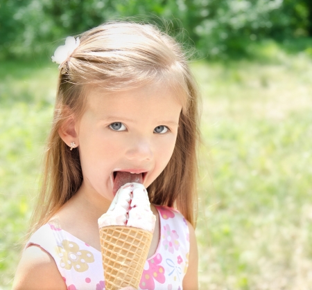 Beautiful little girl eating ice cream outdoor - 20761156