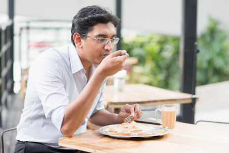Asiatisches indisches Geschäftsmannessen Lebensmittel an der Cafeteria. Foto auf Lager