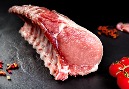 grilled pork: Tươi sống thịt. Xương sườn và thịt lợn chưa nấu chín, cắt sẵn sàng để nướng và thịt nướng. nền đá phiến đen