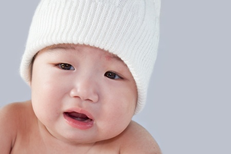 かわいい赤ちゃんは白い帽子を着ています 赤ちゃんは 男の子か女の子になる可能性があります 茶色の目をしています 子育てや愛の概念を使用します の写真素材 画像素材 Image