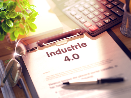 Industrie 4.0- text on clipboard with office supplies on desk. industrie 4.0- text on paper sheet on clipboard and stationery on office desk. 3d rendering. blurred image. Stock Photo