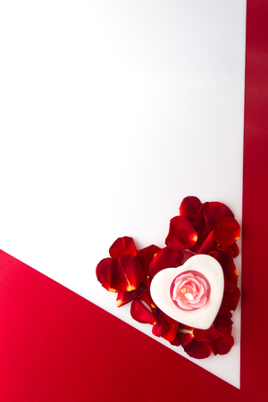 wallpaper International Women s Day: Candle heart on the heart of rose petals corner red white background with space for text