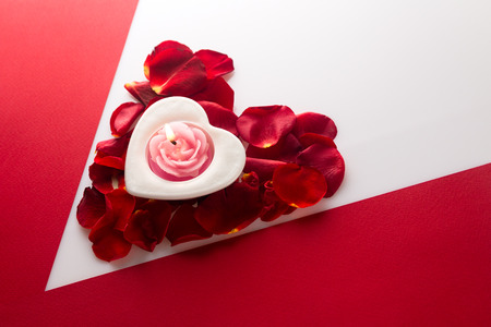 wallpaper International Women s Day: Candle heart on the heart of rose petals corner red white background with space for text