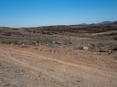 干ばつ砂漠気候と硬岩山風景の背景に澄んだ青い空 乾燥植物 ナミビアで車両タイヤと大まかなほこりの多い未舗装の道路を介して道路の旅行を追跡します の写真素材 画像素材 Image 干ばつ砂漠気候と硬岩山風景の背景に澄んだ青い空 乾燥植物 ナミビアで車両タイヤと大まかなほこりの多い未舗装の道路を介して道路の旅行を追跡します の写真素材 画像素材 Image