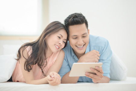 アジア カップル愛好家は スマート タブレットを使用して寝室で一緒にオンライン ショッピングをお楽しみください カップル恋人の幸せ 家族 バレンタインのコンセプトです の写真素材 画像素材 Image 7690