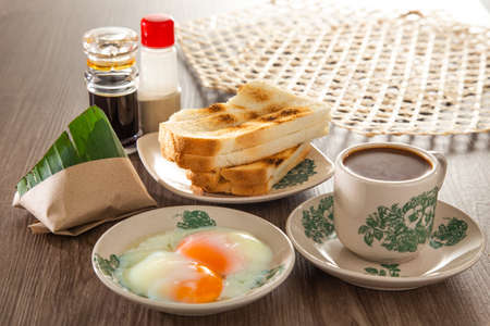 Petit-déjeuner oriental commun en malaisie composé de café, nasi lemak, pain grillé et œuf à la coque Banque d'images