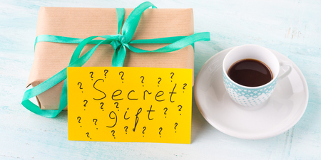 サプライズ誕生日休日プレゼント ボックス グリーン リボンとエスプレッソ コーヒーのカップをラップします イエロー カード スペル言葉秘密ギフトの概念 の写真素材 画像素材 Image