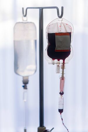Zapasowe worki na krew z laboratorium medycznego wiszące na stalowym słupie w szpitalu w celu przygotowania krwi do żył pacjentów, którzy chcą oddać krew w tej samej grupie