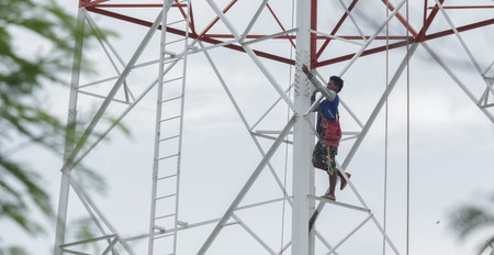 Workers demolition telephone poles due to health complaints.Mahasarakham,Thailand,July 2016