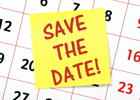 the words save the date in red text on a yellow sticky note posted