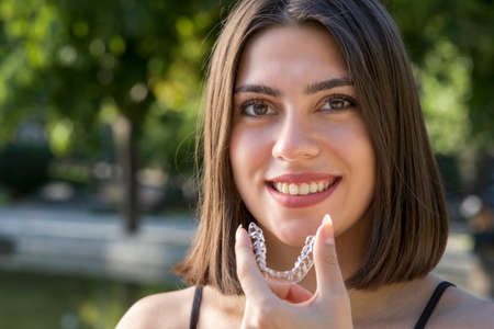 Piękna uśmiechnięta turczynka trzyma naramiennik invisalign Zdjęcie Seryjne