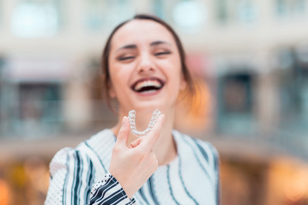 Beautiful smiling turkish woman is holding an invisaligner