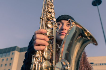 美しい若い女性が彼女のサックスと街の通りにポーズ の写真素材 画像素材 Image