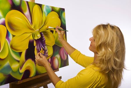 A female artist painting dendrobium orchids on canvas in her studio