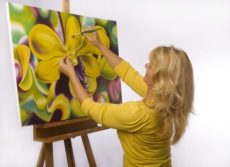 A female artist painting dendrobium orchids on canvas in her studio