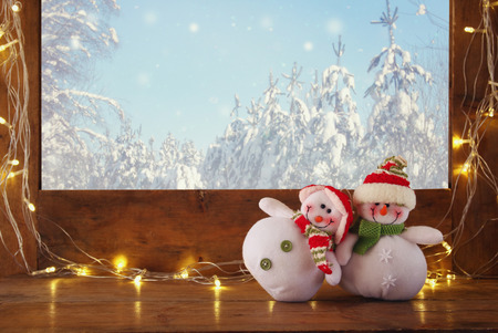 old window sill with gold christmas lights and cute snowmen in christmas lights snowmen