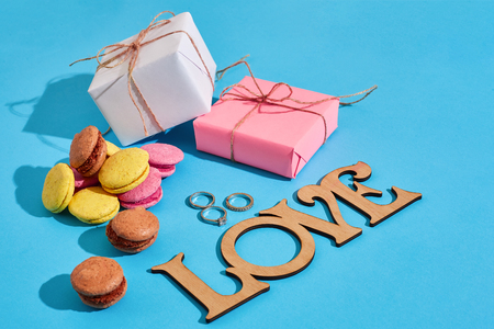 Macaroons and gift boxes on a blue background with the words love