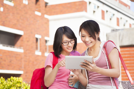 two students using a tablet to discuss homework - 26273940