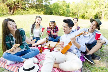 glückliche junge Freundgruppe, die Picknickpartei genießt Foto auf Lager