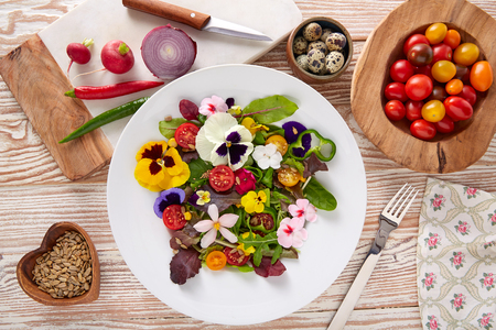 Edible flowers salad in a plate with ingredients Stockfoto