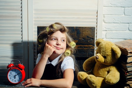 クマと目覚まし時計を持つ子供 本を持つ子供 教育と子供時代 小さな赤ちゃんの秘書 髪にカーラーを持つ小さな女の子 の写真素材 画像素材 Image