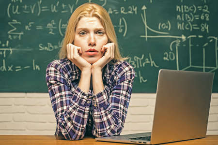 Start-up. nerd funny student preparing for university exams. high school. portrait of tired serious female student. student sitting at desks in classroom and demonstrating bad behavior.