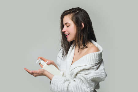 Fille appliquant un conditionneur de cheveux. traitement des cheveux des femmes. femme tenant une bouteille de shampoing et de revitalisant.