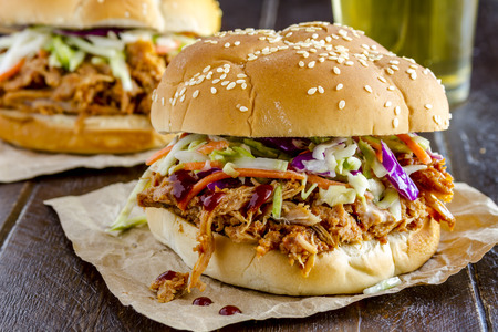 grilled pork: Đóng lên chui thịt lợn nướng bánh sandwich với xà lách trộn ngồi trên bàn gỗ với ly bia