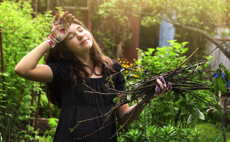 stock photo teenager girl work in the garden tired wipe her forehead summer photo