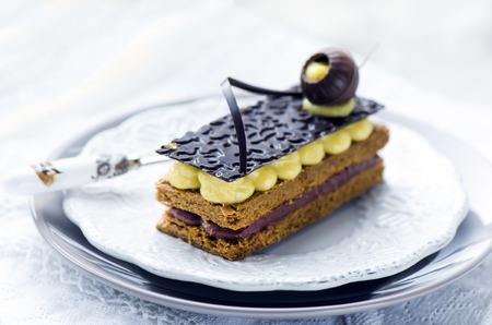 Millefeuille Franzosisches Geback Mit Vanillepudding Und Schokolade Auf Einer Weissen Platte Und Einem Holztisch Lizenzfreie Fotos Bilder Und Stock Fotografie Image