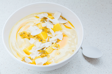 ココナッツ グラノーラ パッションフルーツのマンゴースムージーボウル 健康的なビーガンダイエット朝食のコンセプト の写真素材 画像素材 Image