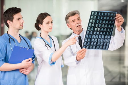 Group of doctors looking at X-ray at offie. Stock Photo - 40998030