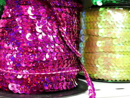Background sequin.glitter surfactant. holiday abstract glitter background with blinking lights. fabric sequins in bright colors. fashion fabric glitter sequins.
