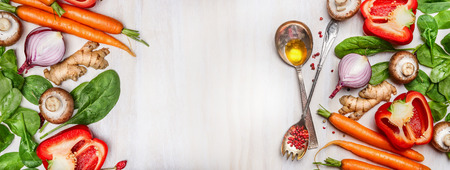 Légumes propres bio assortis avec cuillères à cuisson et huile sur fond en bois blanc, vue de dessus, bannière. Concept d'alimentation saine, végétalien ou régime alimentaire.