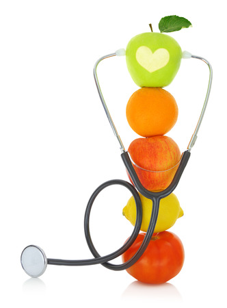 Stéthoscope avec des fruits frais isolés sur blanc Photo