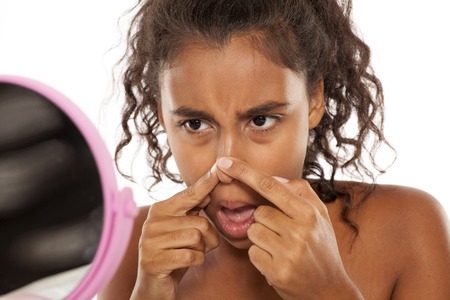 若い女性が鏡の中の彼女の鼻毛のチェック の写真素材 画像素材 Image