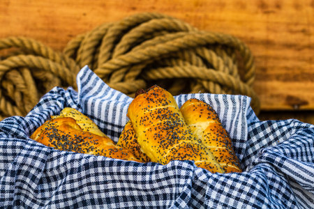 Sausages baked in dough sprinkled with salt and poppy seeds in a rustic composition. sausages rolls, delicious homemade pastries.