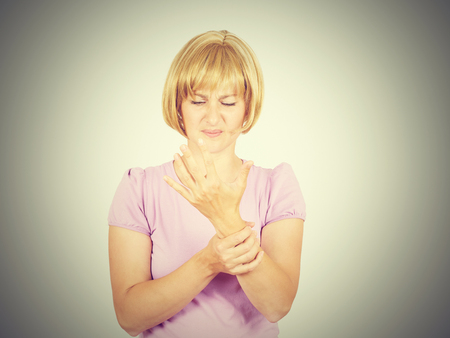 クローズ アップ肖像画の若い女性は 背景に分離されて痛い手首を保持しています 捻挫の痛み Armache の写真素材 画像素材 Image