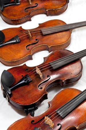 several used fiddles on white background close up stock photo
