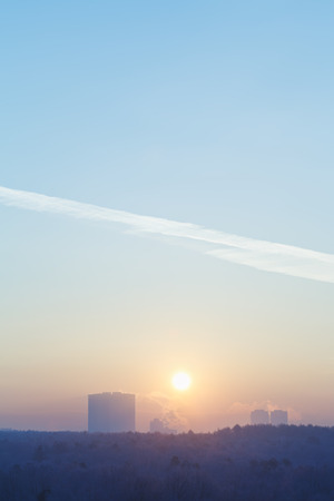 冬の寒い朝の都市の上の青い空に日の出の太陽 の写真素材 画像素材 Image