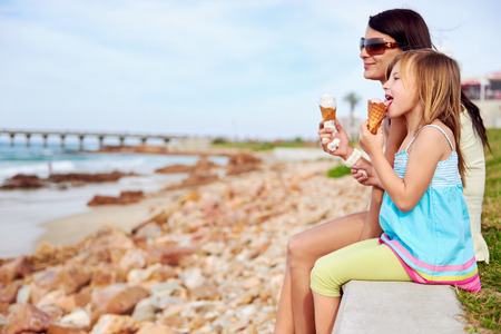 ice cream: Mẹ và con gái thích ăn kem vui vẻ tại bãi biển mỉm cười cười vui vẻ trong kỳ nghỉ hè Kho ảnh
